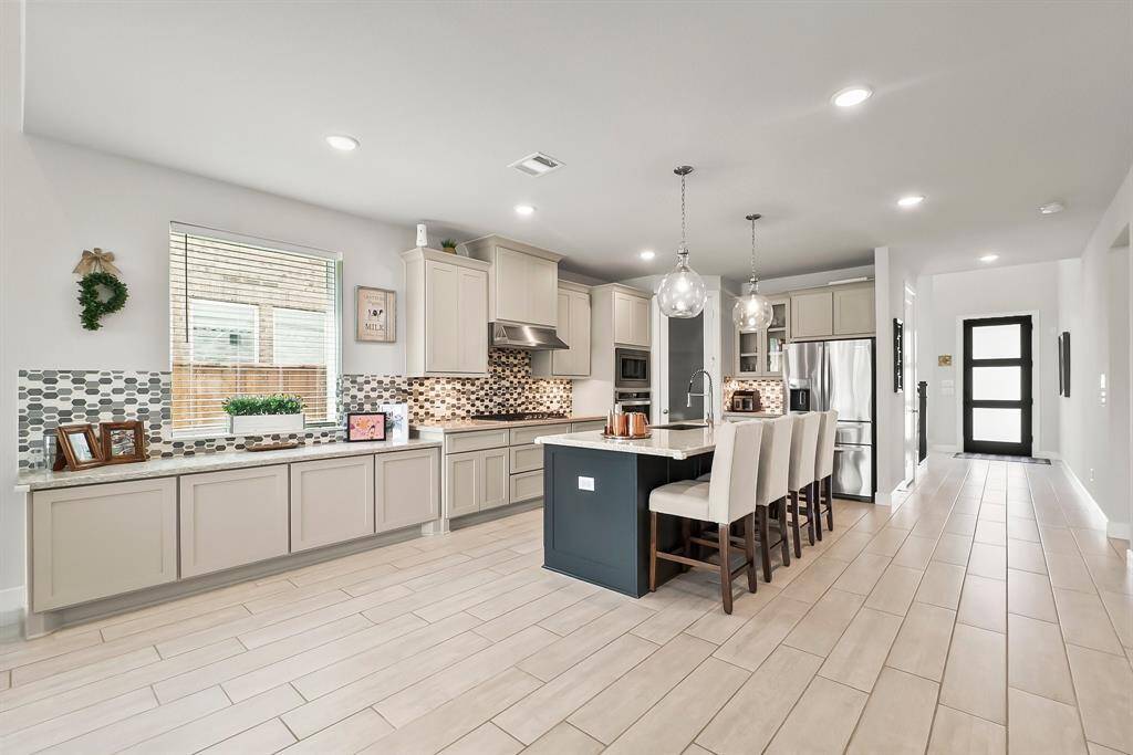 An open floorplan with low maintenance wood-look tile throughout.