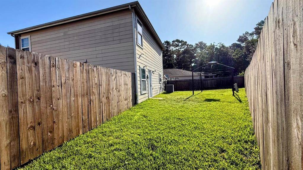 Spacious backyard with well-maintained lawn, surrounded by wooden fencing for privacy. Ideal for outdoor activities and relaxation