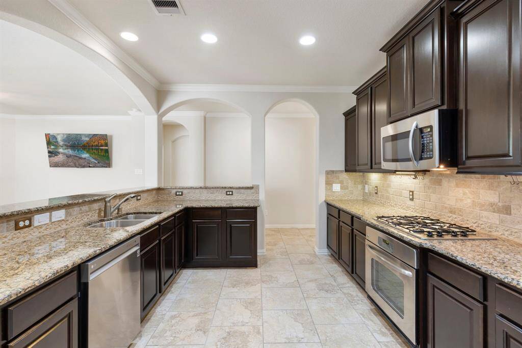 Under-cabinet lighting enhances functionality while the overhead recessed lighting ensures a bright and welcoming space.