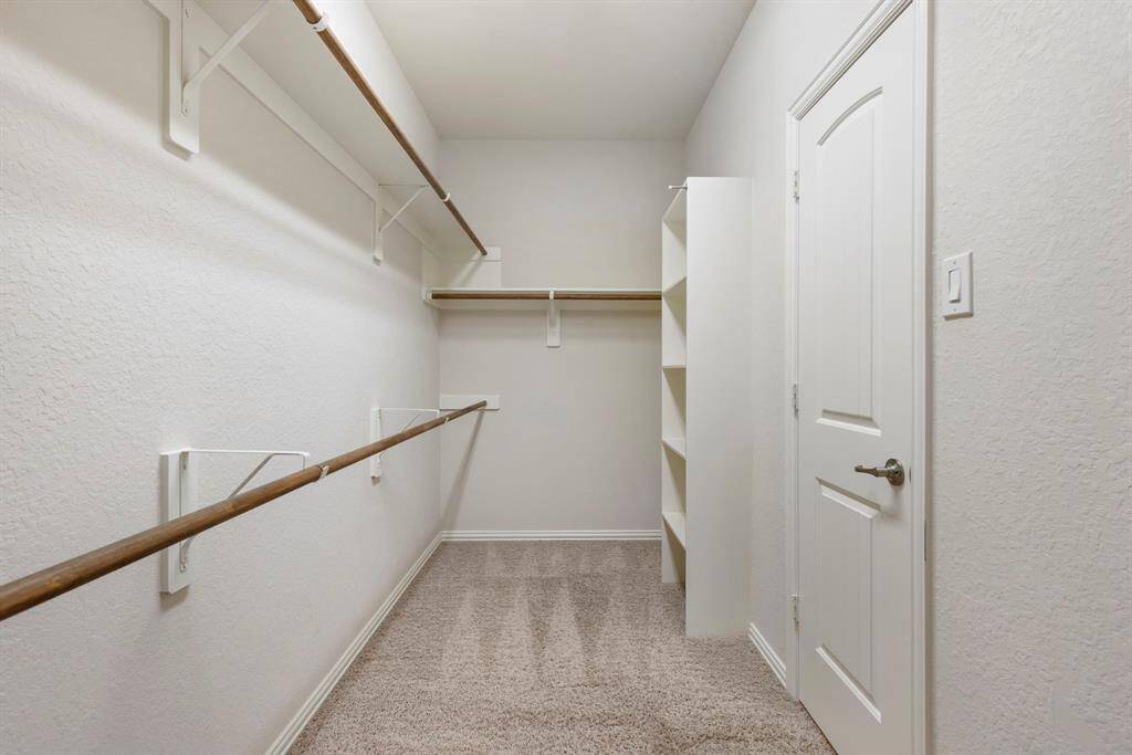 Expansive primary closet has plenty of hanging space and built in shelving.