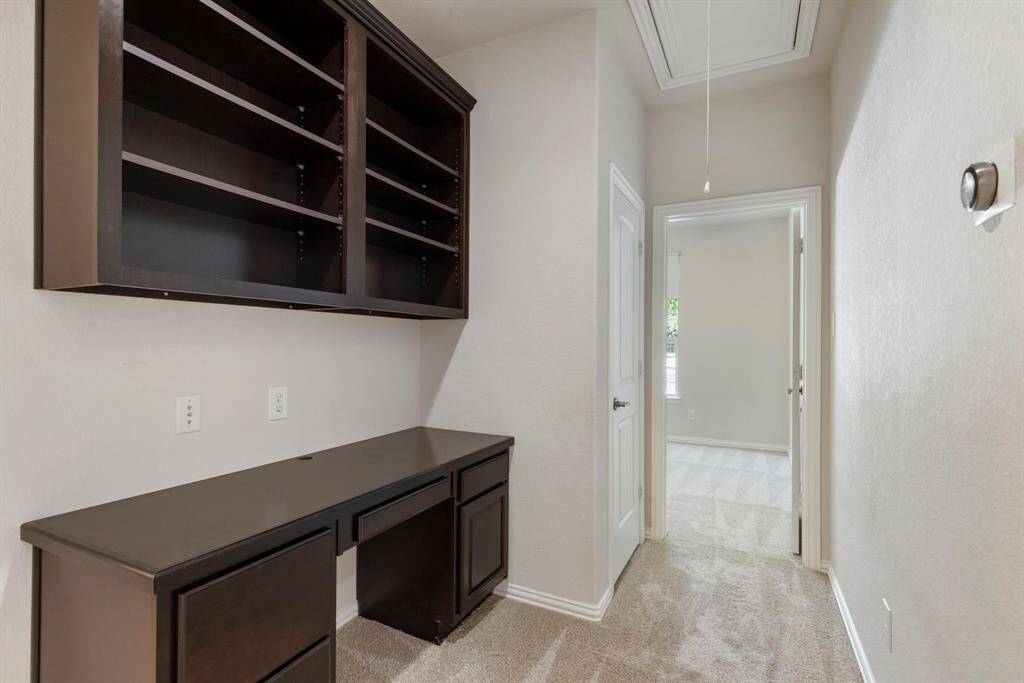 Conveniently located between two secondary bedrooms, this built-in study nook offers the perfect spot for homework, remote work, or creative projects. Thoughtfully designed with open shelving and an integrated desk, it provides both workspace and storage.   Ideal for students or a home office setup!