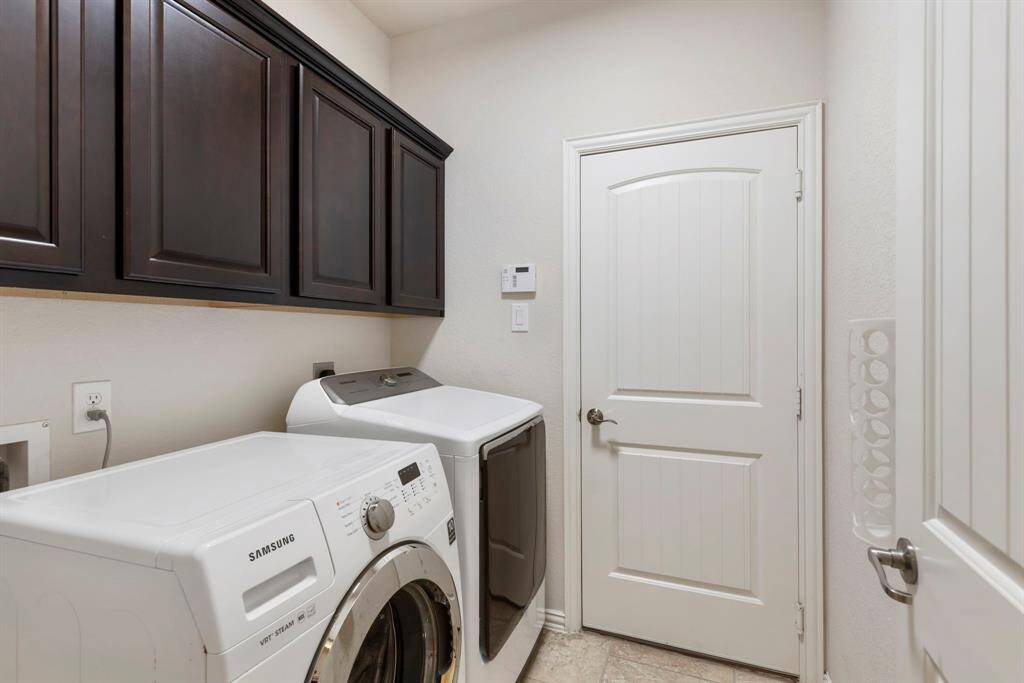From the garage, there is a laundry room with storage. Samsung clothes washer and dryer stay with the home!