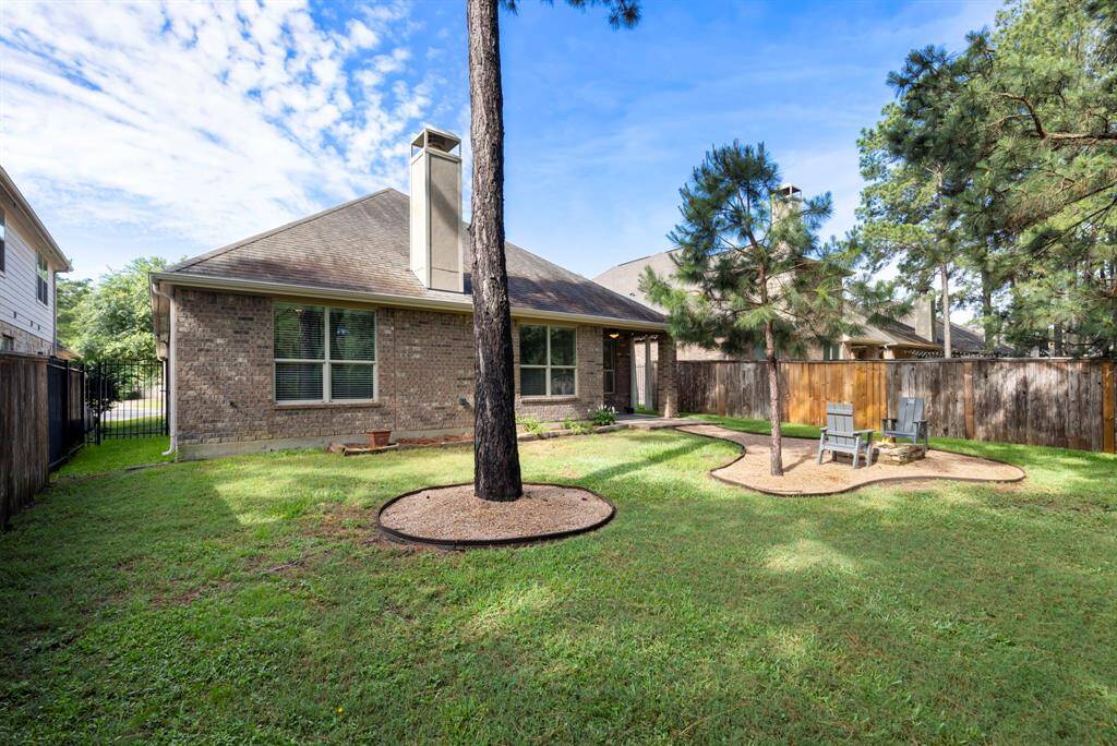The backyard offers plenty of green space, optimal for play, gardening, or simply enjoying the view.