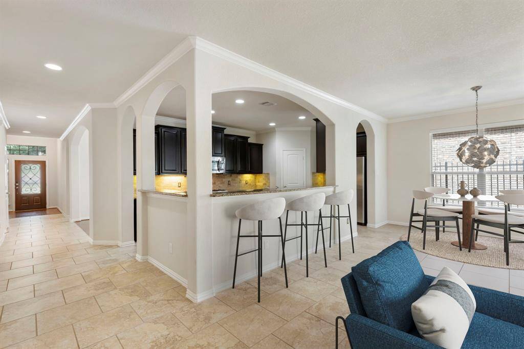 Thoughtfully designed as the heart of the home, the kitchen opens gracefully to the family room through arched openings, creating a seamless flow for daily living and gatherings. A breakfast bar offers additional seating and a casual spot for entertaining, making this space both functional and inviting. * This image has been virtually staged.