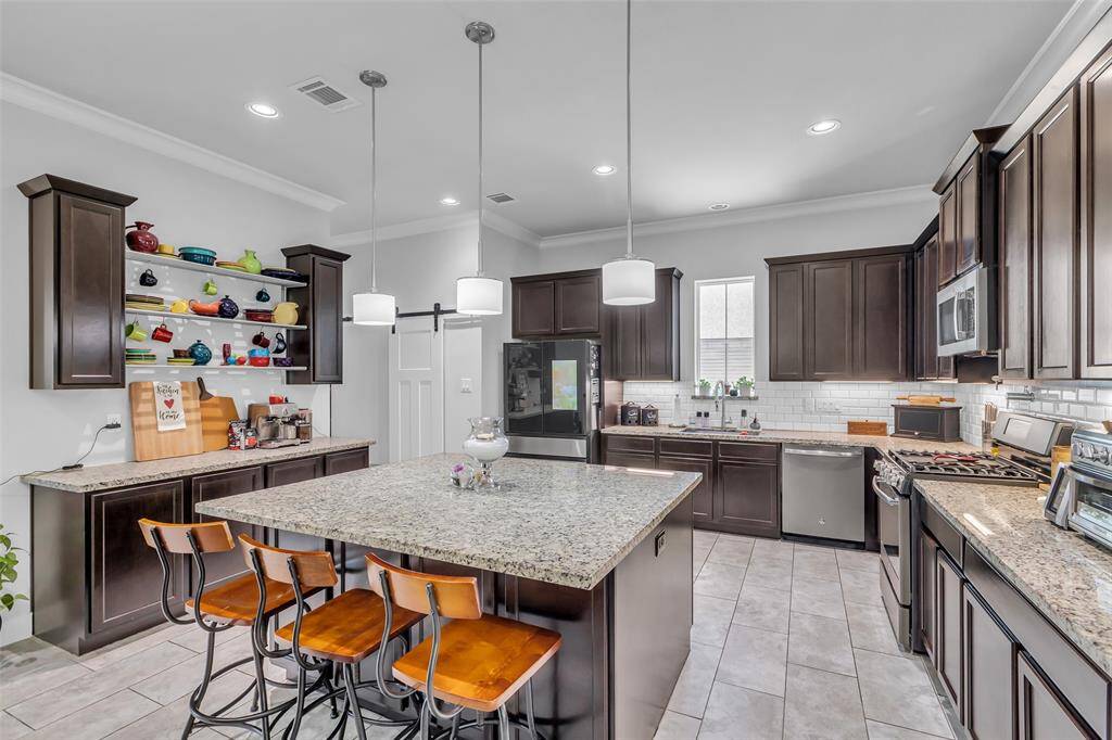 A wider view of the kitchen reveals its functional layout, designed for efficiency and ease of movement, with ample counter space and a central island that enhances usability.