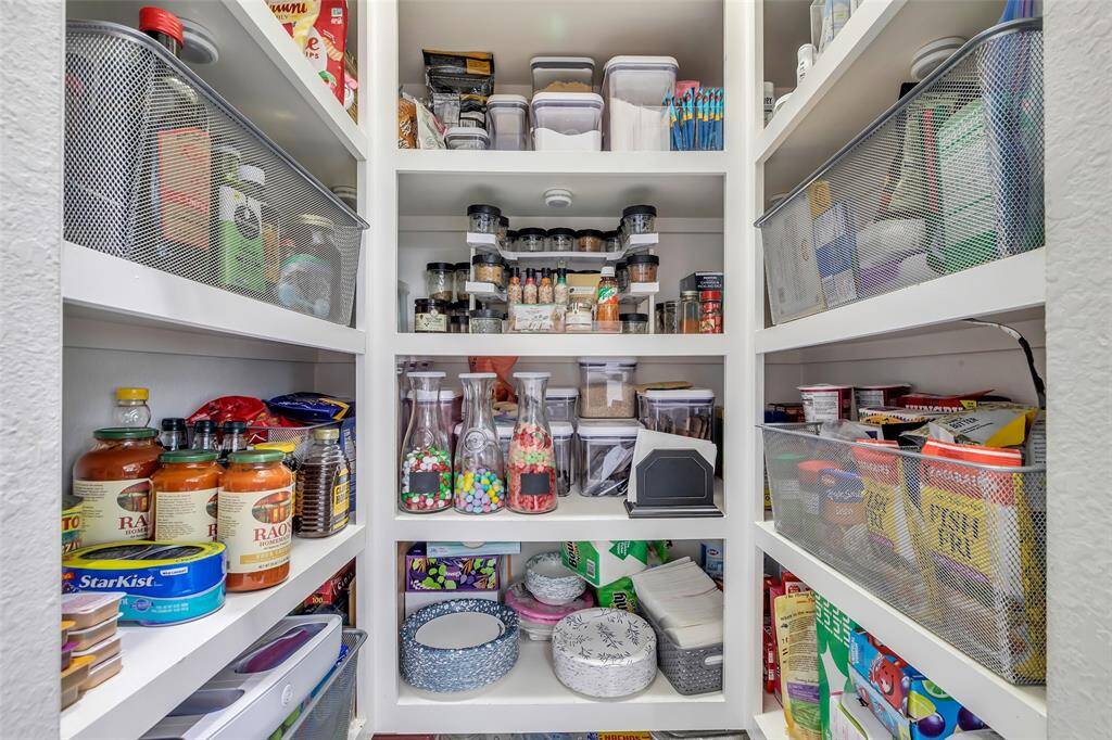 Inside the walk-in pantry, there’s plenty of space to organize your kitchen supplies for easy access and efficient storage.