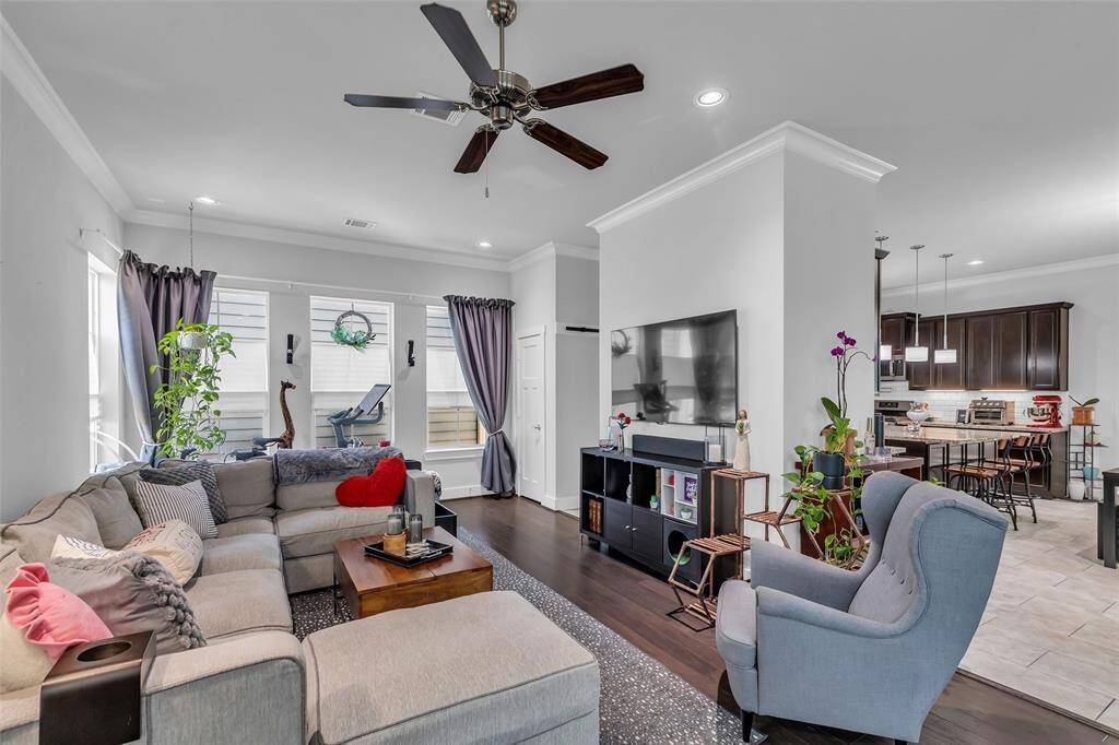 Step into the living room, where an open layout connects seamlessly to the kitchen and dining area. A peek of the kitchen in the background hints at the home's thoughtful flow and design.