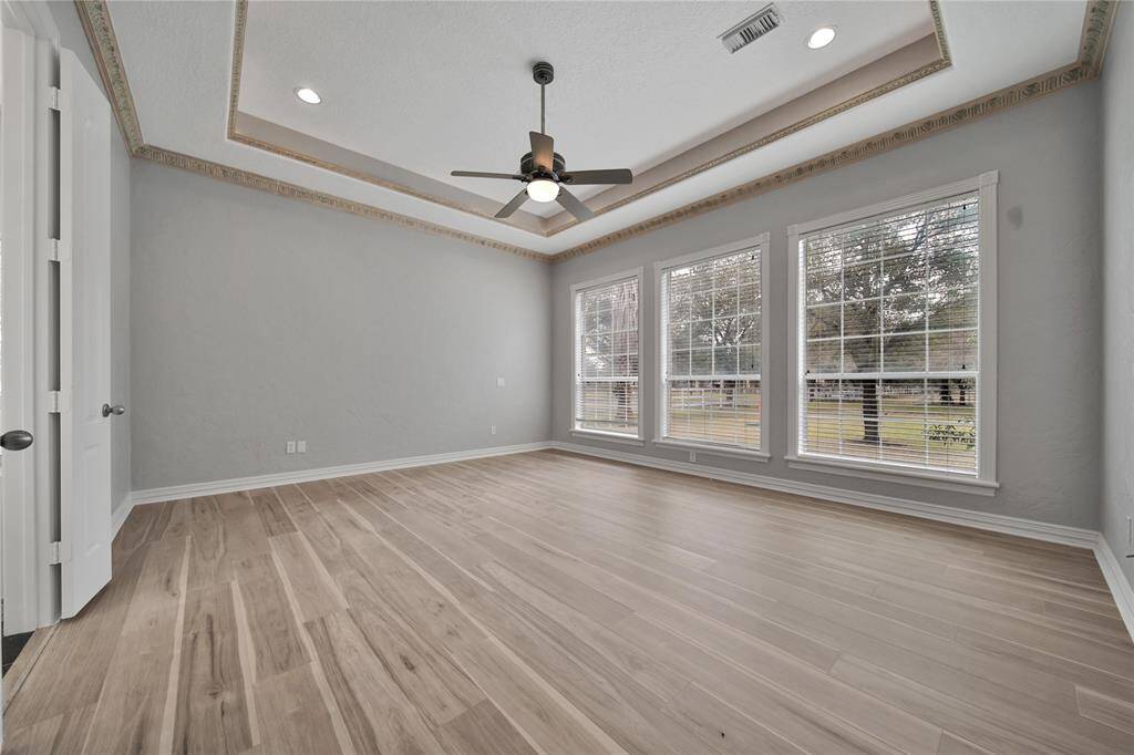 A grand primary suite with a dramatic tiered ceiling.