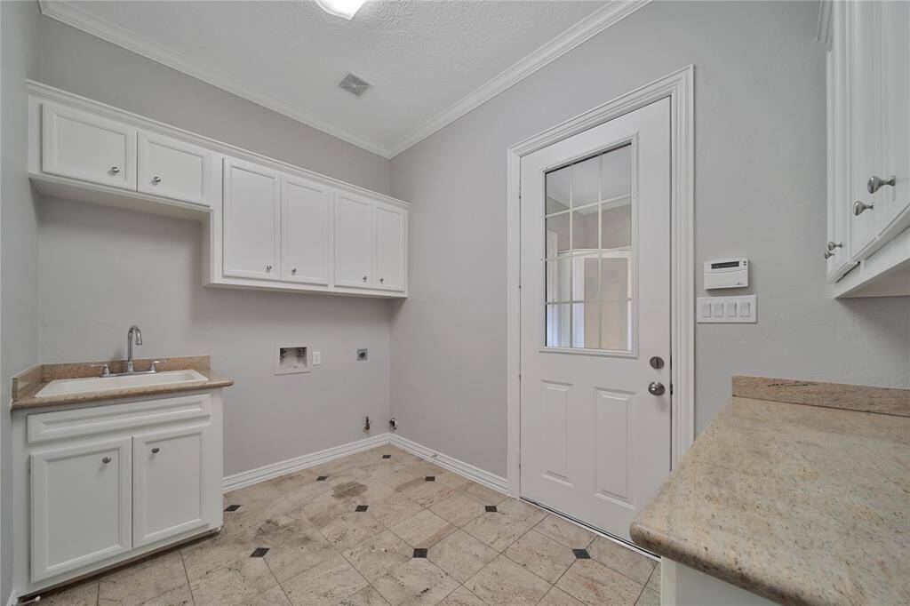 Laundry Room w/sink and folding counter, cabinets and space for deep freeze.