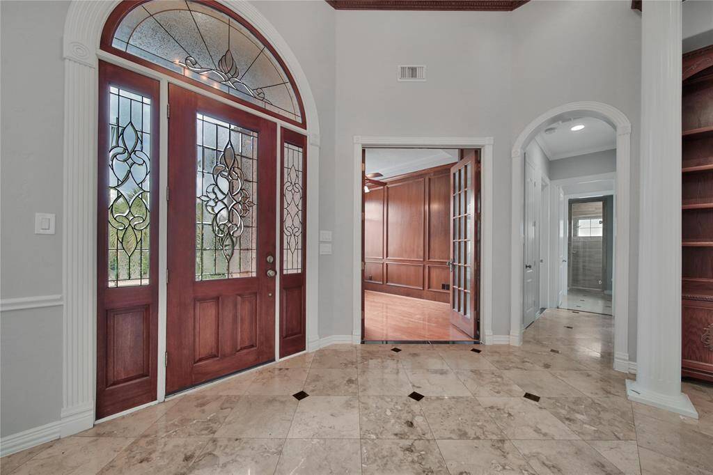 Impressive grand entrance with elegant glass leaded front doors and marble flooring.