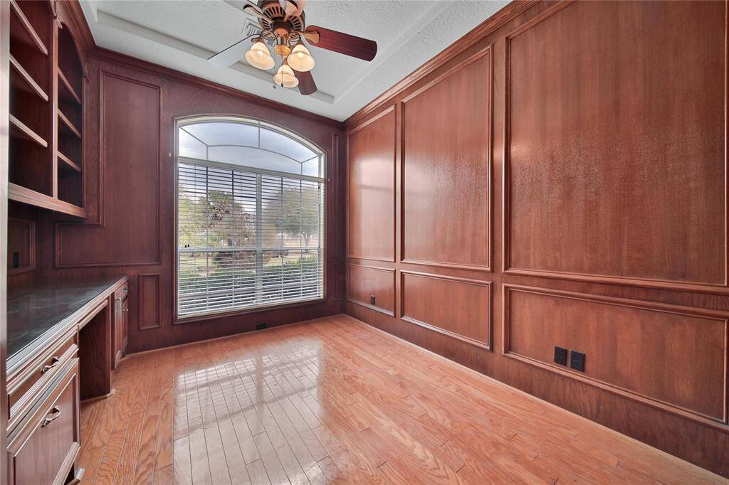 Study with French doors, built-in desk, and wood paneling.