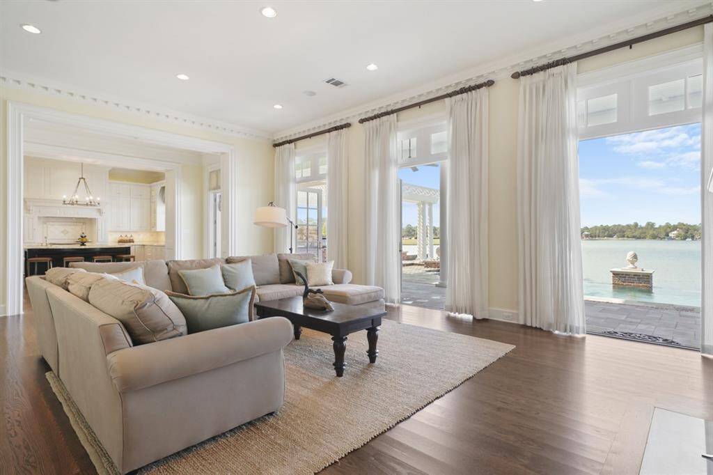 Open concept first floor living with 12' ceilings seamlessly transitions from the family room, kitchen, and breakfast rooms. Family room has 3 sets of French Doors that open to a spectacular view of the pool and lake with the feeling of being on a boat in open water because of the continuous water views. Sound system further contributes to the ambience.