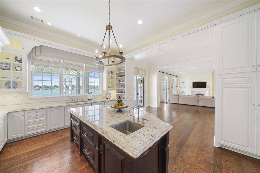 Incredible lake views while you prep! Inviting, sunny, light-filled and bright open concept floorplan. Large crescent shaped island kitchen offers plenty of seating and has a built-in slide-out microwave and second sink w/disposal. Main prep area features a double sink and bridge faucet with pull-out spray and disposal. Grohe fixtures and Elkay Lustertone Stainless Steel sinks.