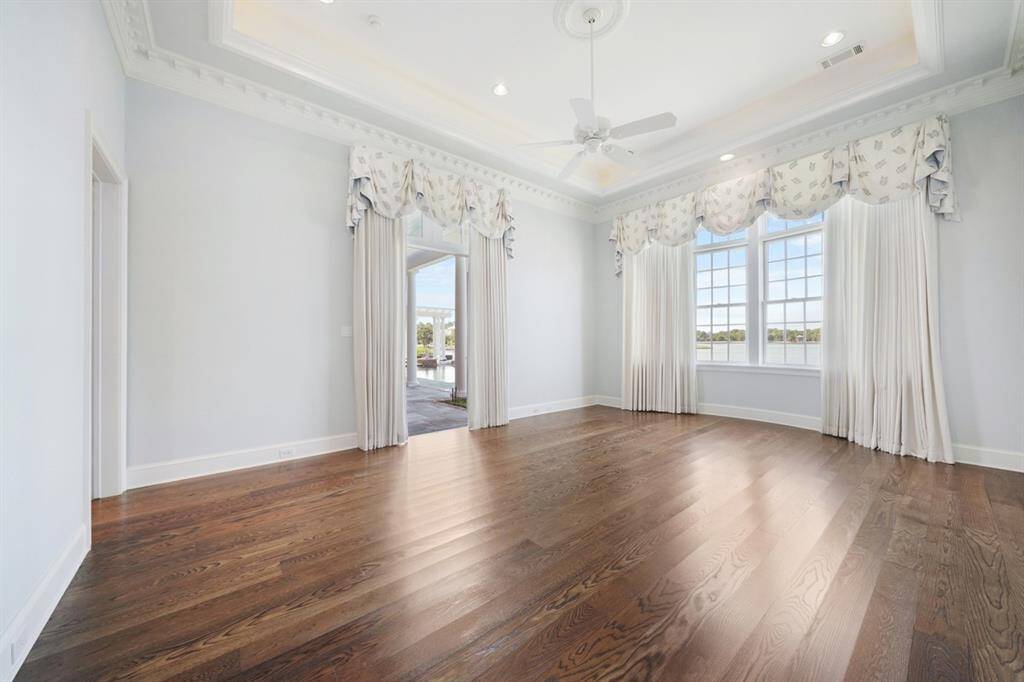 Graciously sized Owner's Retreat with Bay Windows and sitting area. French Doors open to the covered patio and pool. Wake up to the relaxing views of the lake and let the soothing sound of the pool waterfalls lull you to sleep.