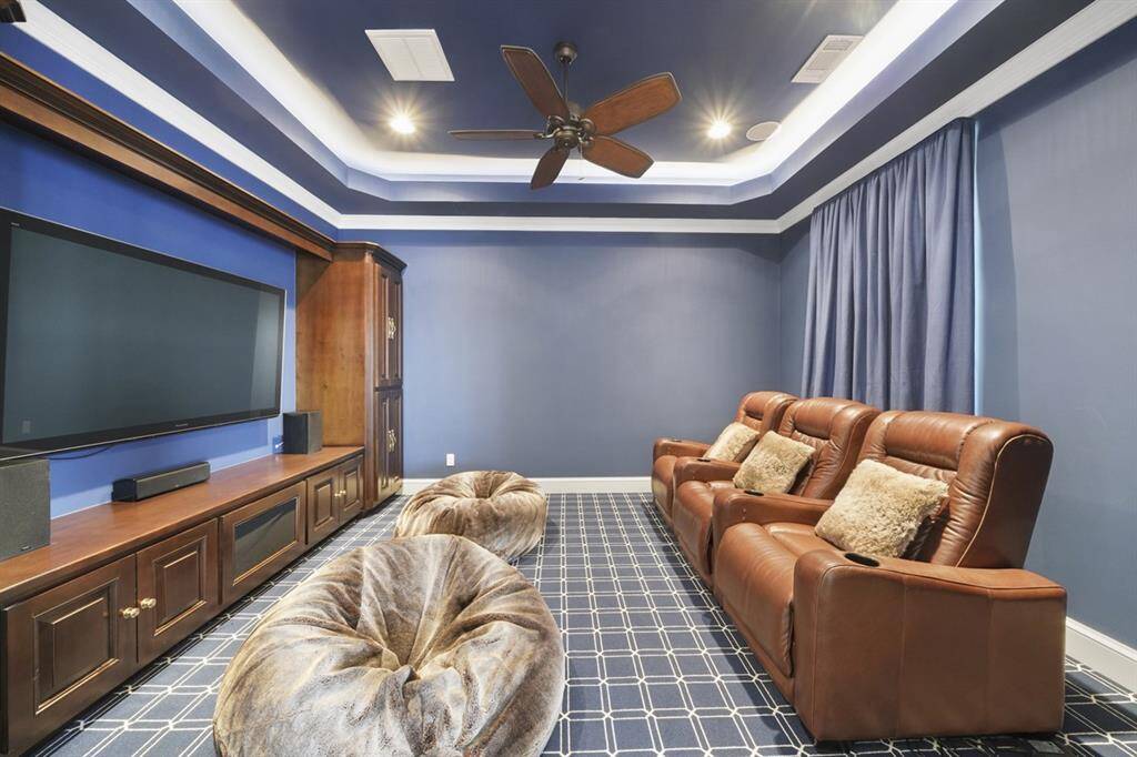 Knotty alder media room with surround sound system, LED cove lighted ceiling, and luxury Stark carpet. Curtains open to lake view. Perfect for popcorn movie nights!