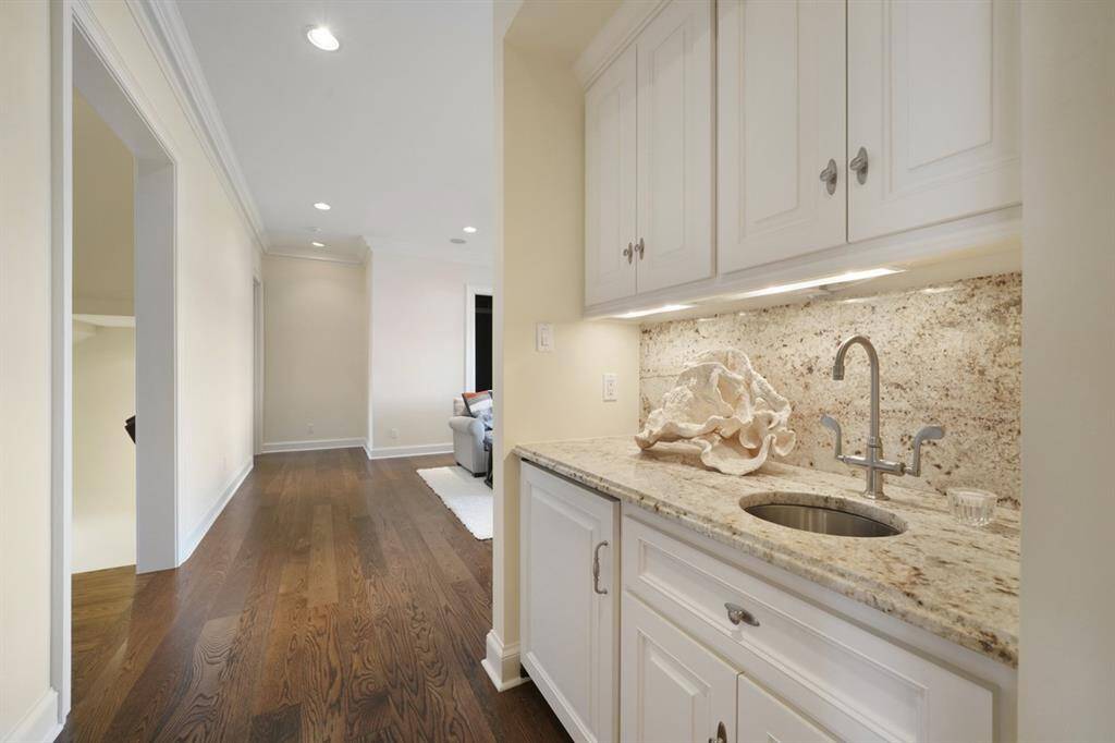Upstairs wet bar with sink, cabinets, under cabinet lighting, integrated undercounter SUB-ZERO refrigerator/ice maker. Level 3 Colonial Cream Granite countertop and wall backsplash.