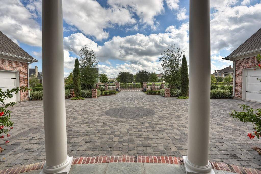 HUGE motor court with a multitude of parking options. Concrete pavers with circular contrast detail. Oversized newly epoxied 5 car garage with additional room for work space, smart vehicle, golf cart, or motorcycles.