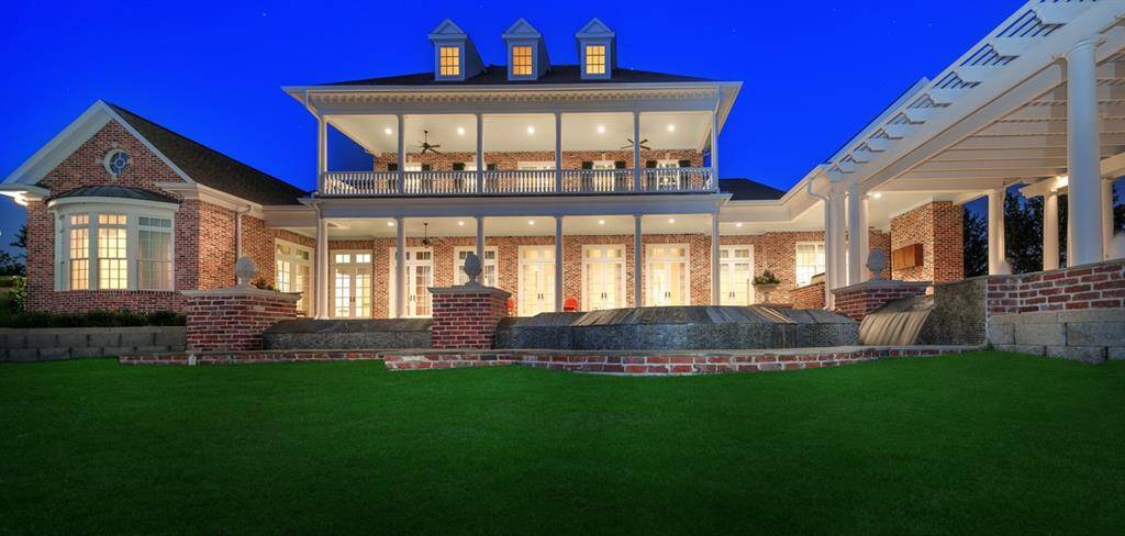 Evening view of the home with LED outdoor lighting. Plenty of yard space beyond the pool to gaze at the stars.