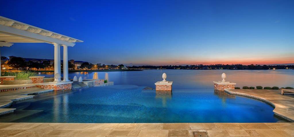 The Pebble-tec Infinity edge pool/spa and lake becomes one continuous seamless transition and provides a relaxing respite. Pool color was selected to mimic the colors of a turquoise beach. Versailles pattern Quartzite decking with mica accents stays cool underneath the feet in the hot Summer months. New spa heater.