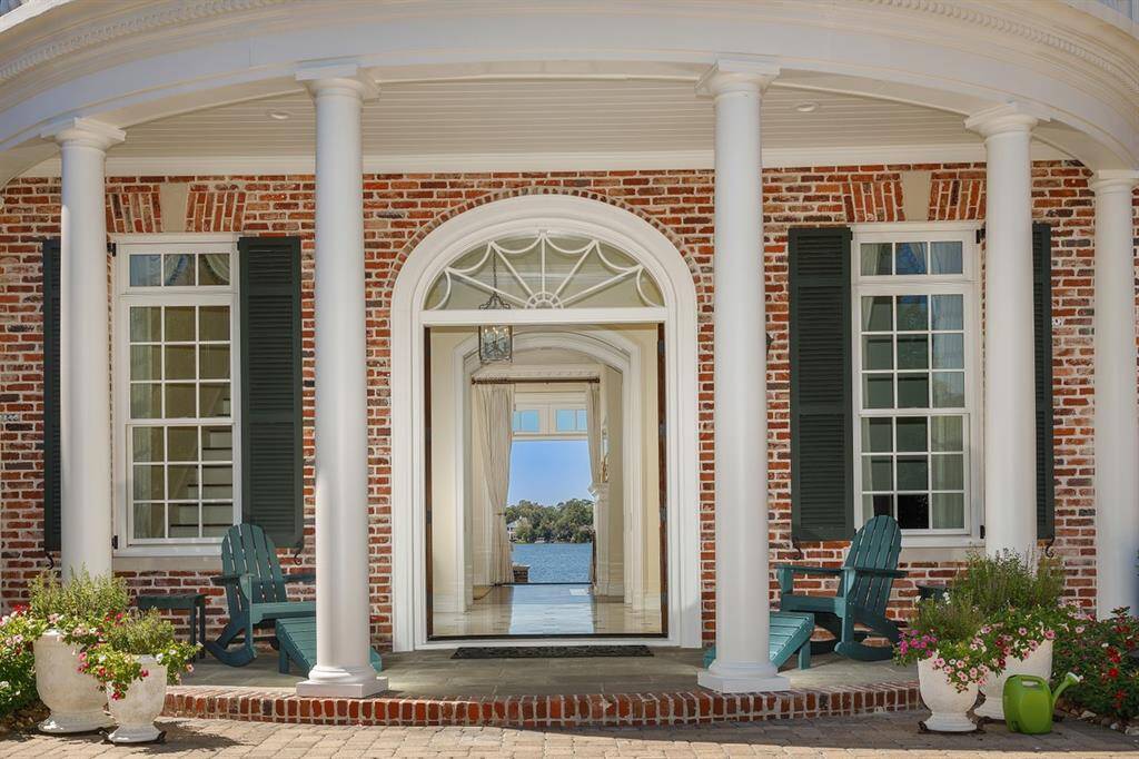 Solid Mahogany double front doors open graciously to a magnificent view of the lake. Fully functional rot-proof upgraded Timberlane shutters with iron shutterdogs.