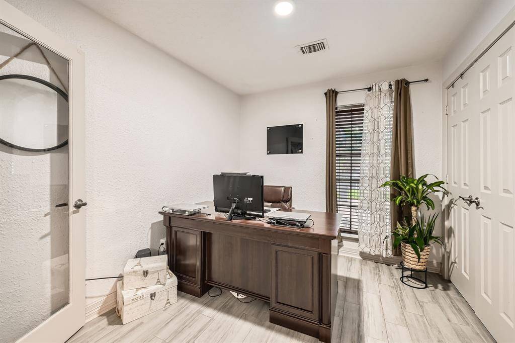 3106 Village Springs Ct. This room is currently being used as  home office, neutral walls, and wood-look flooring. It has large windows with elegant and ample lighting, creating a functional and inviting workspace.