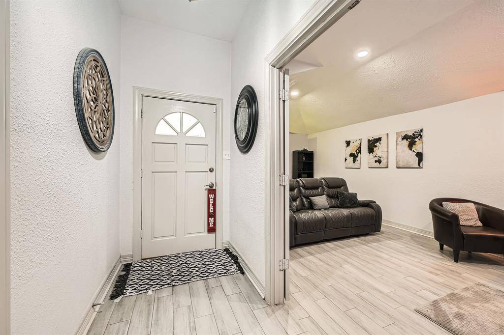 3106 Village Springs CT showcases a welcoming entryway  The adjacent living room against light wood flooring and soft lighting.