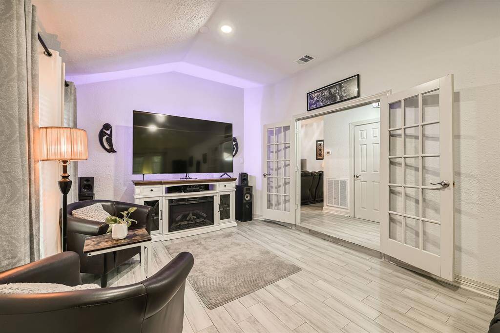 3106 Village Springs CT showcases a cozy living room with modern recessed lighting, and French doors open into an adjacent room, enhancing the open layout.