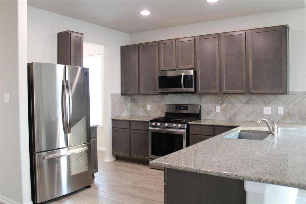 Great angle of the kitchen, notice all stainless steel appliances and gas stove