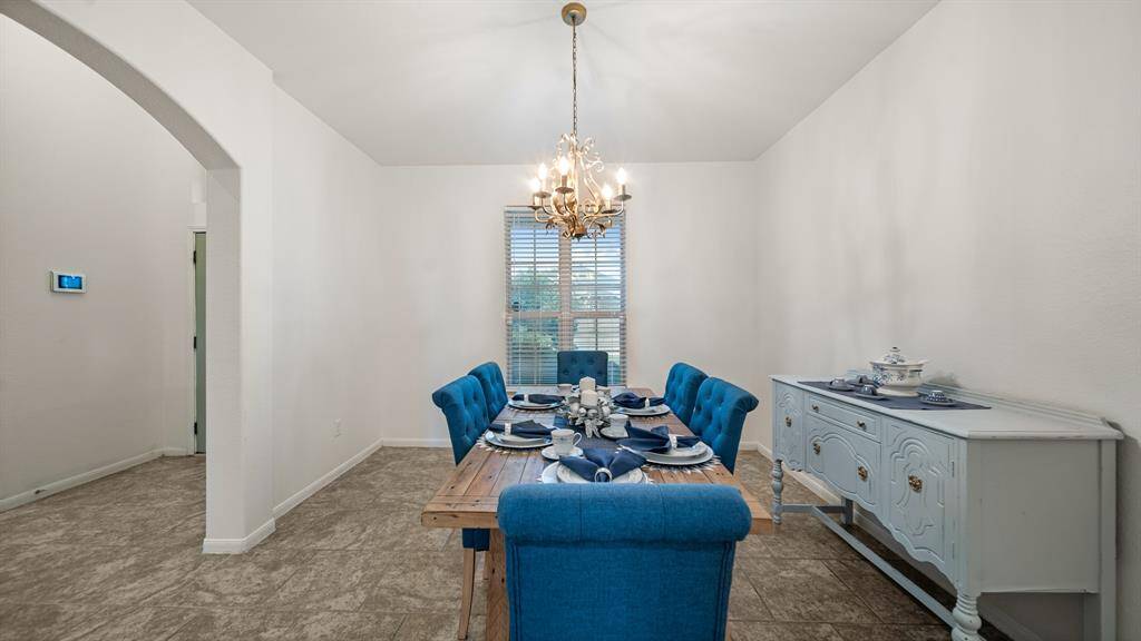 The luxury fixture adds to the upscale atmosphere, with a dazzling chandelier casting a soft, flattering light over the space.