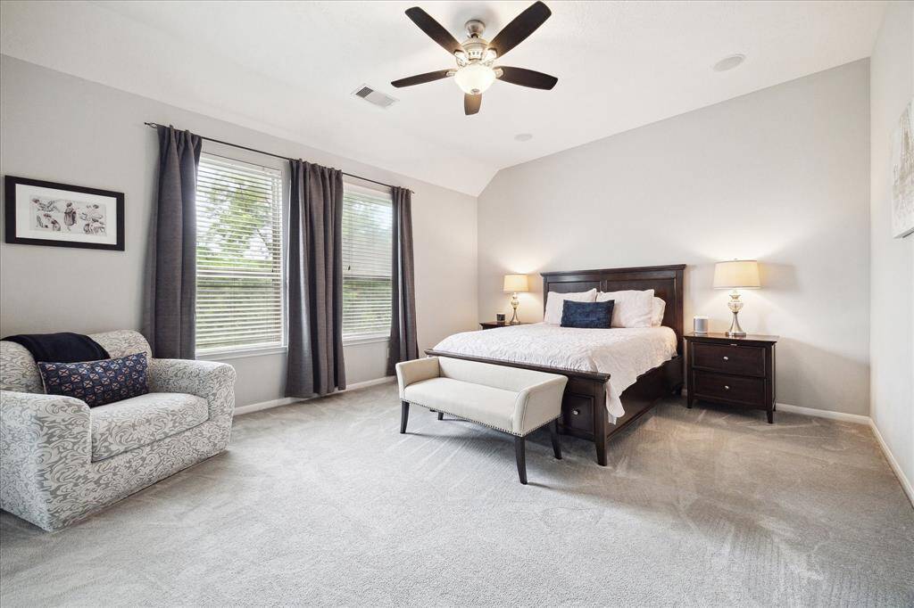 The primary bedroom is a luxurious retreat with a double-door entry leading to an ensuite bathroom. It boasts a generous walk-in closet and ample space for relaxation.