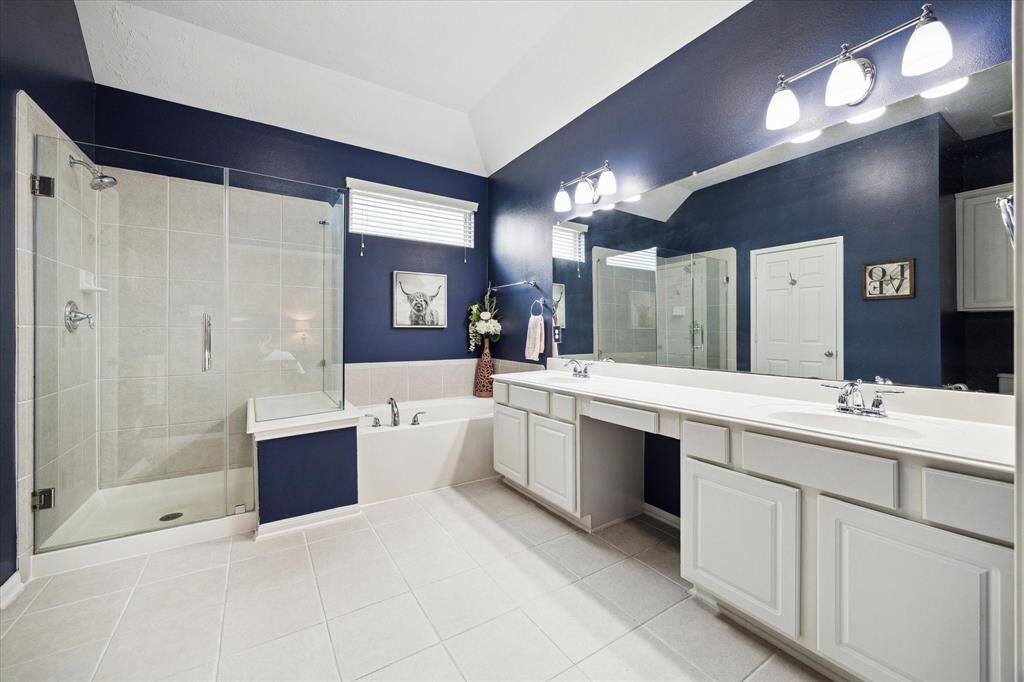 The primary spa is a luxurious retreat, featuring a standalone shower with a built-in bench, a soaking tub, dual vanities, and an expansive walk-in closet.