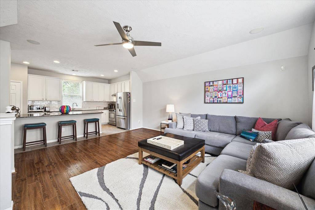 Step into the expansive living room featuring 10-foot ceilings and large windows that flood the space with natural light. The open-concept design seamlessly connects to the kitchen, making it perfect for entertaining.