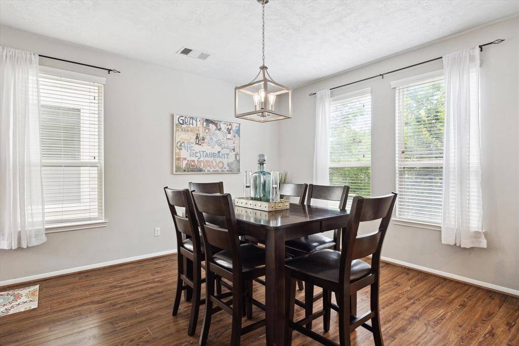 The dining area at 3328 Leading Point is a bright and inviting space, bathed in natural light from large windows. This area seamlessly connects to the open-concept living and kitchen spaces, creating an ideal setting for both intimate dinners and larger gatherings.