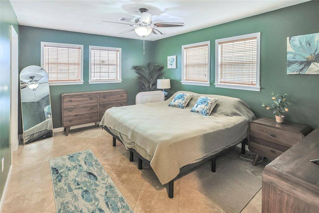 This lovely primary bedroom features several windows that provide lots of natural light, and the ample size accommodates many furniture layouts. The ensuite is off to the left.