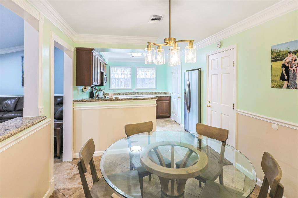 The designated dining area features updated lighting fixtures and fresh paint with open access to the kitchen- making mealtime a delight.