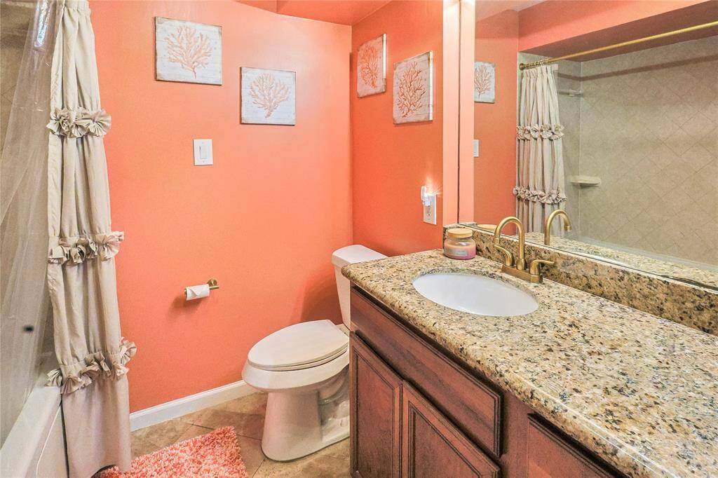 Full secondary bathroom with granite countertops and a shower/tub combo.