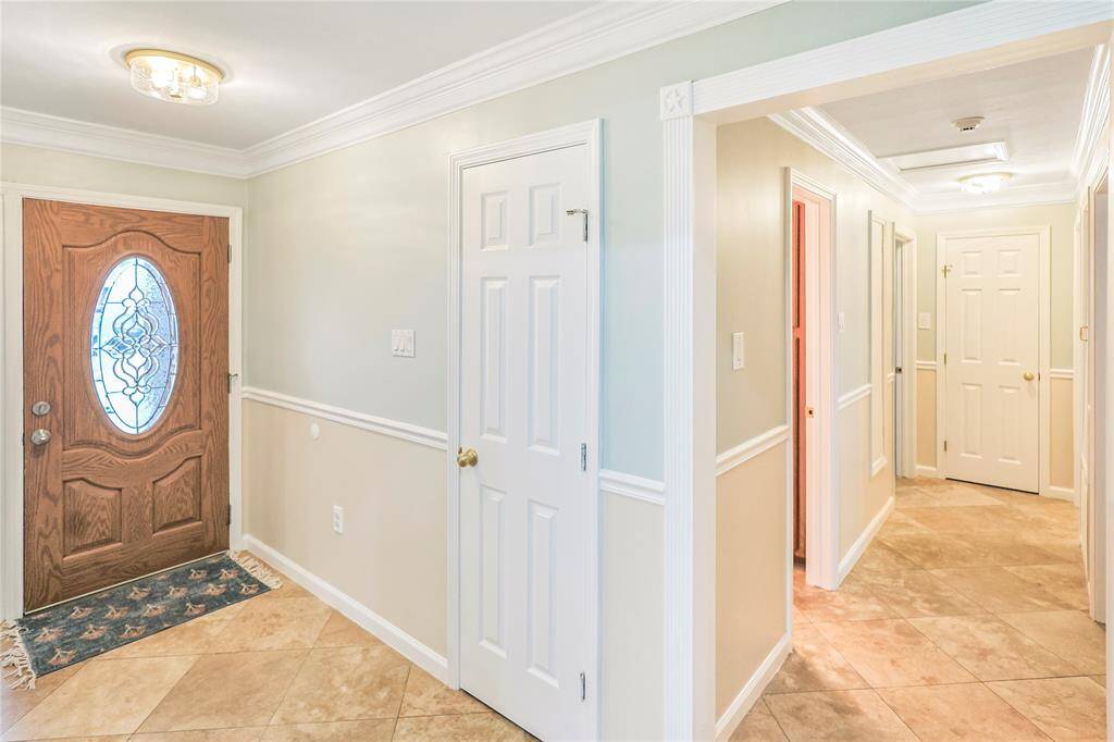 The entry is bright and airy and features a closet for storage.  Notice the beautiful tile flooring, the new interior paint.  The bedrooms are down the hall.