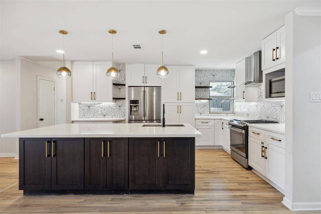 Another view of the gorgeous newly renovated chefs kitchen featuring large island with deep storage behind the doors offering great functionality