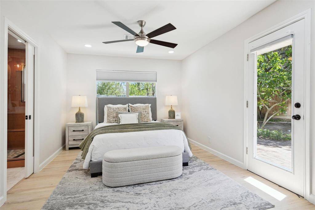 Primary bedroom featuring a fireplace and newly installed hardwood floors in 2024. The door to the left opens out to the backyard