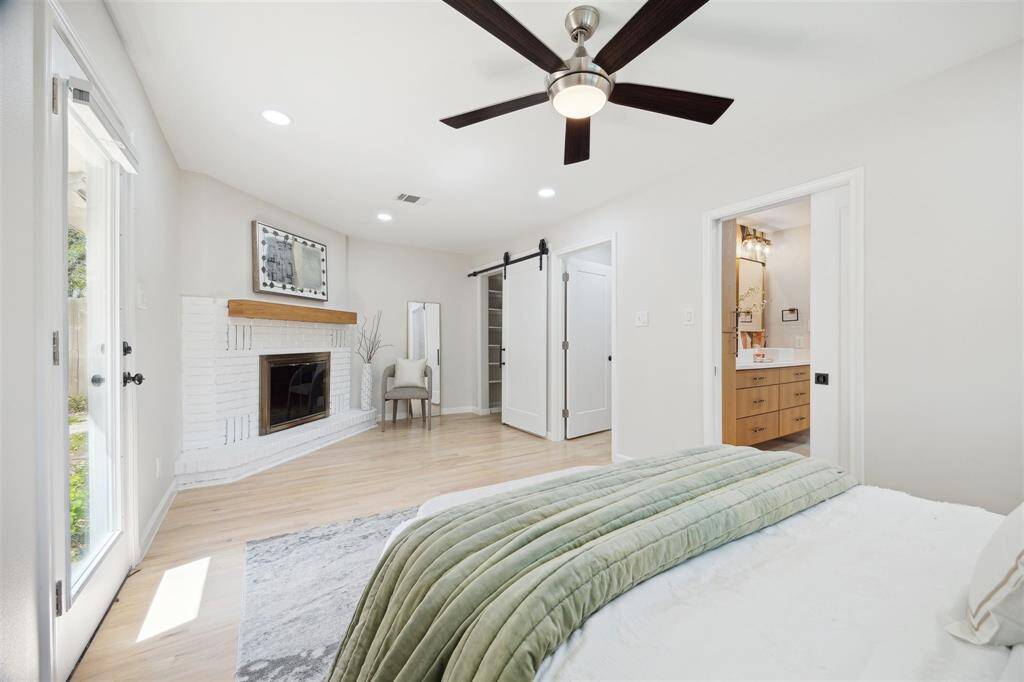 Another view of the primary bedroom showing access to backyard patio through the side door on the left.