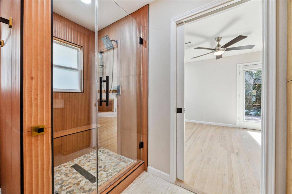 another view of the primary bathroom with spacious walk in frameless glass shower