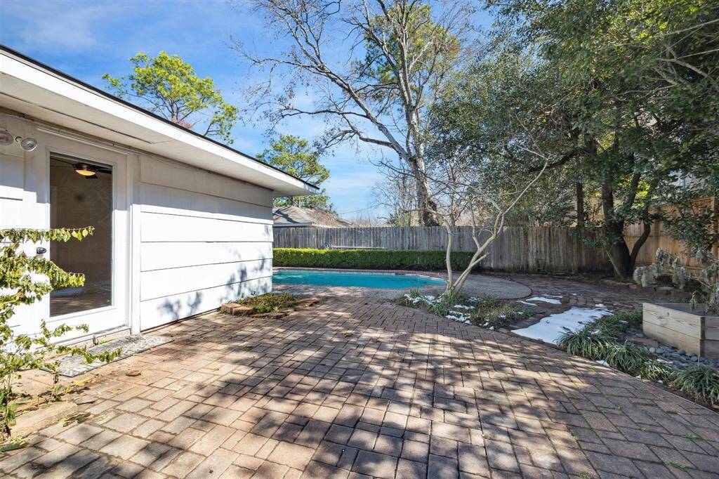 Backyard patio opening out from primary bedroom looks . A great space for entertaining