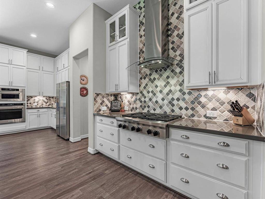 Fabulously designed kitchen w/ over-sized drawers, granite to ceiling backsplash, elegant kitchenaid appliances, and cabinet uppers!