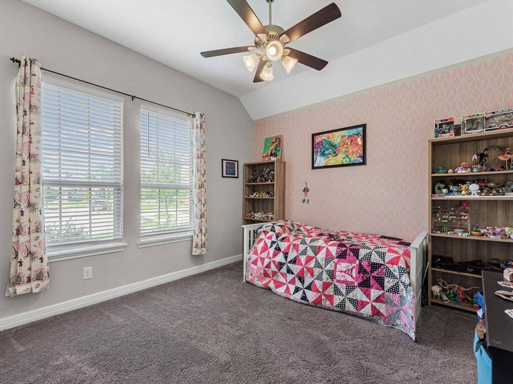 Spacious secondary bedroom with soft natural light, neutral tones, and ample closet space.