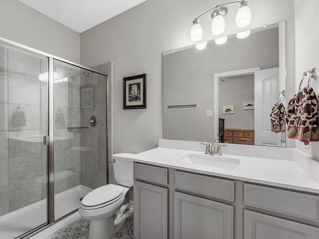Private ensuite bathroom located within the secondary bedroom, featuring a sleek vanity, modern fixtures, and a large walk-in shower.