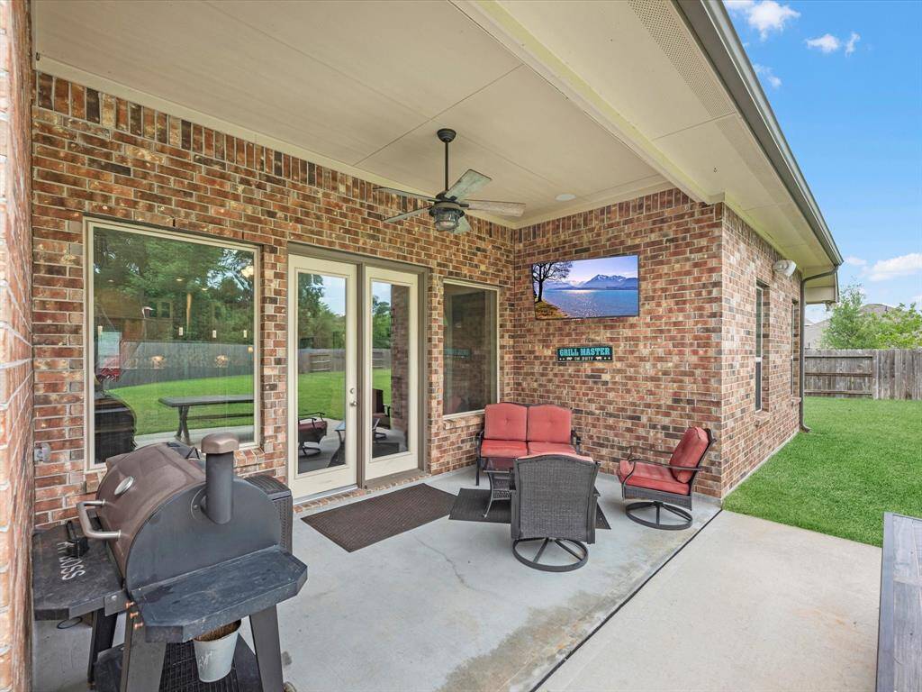 The covered patio is generously sized, providing ample space for various outdoor activities.