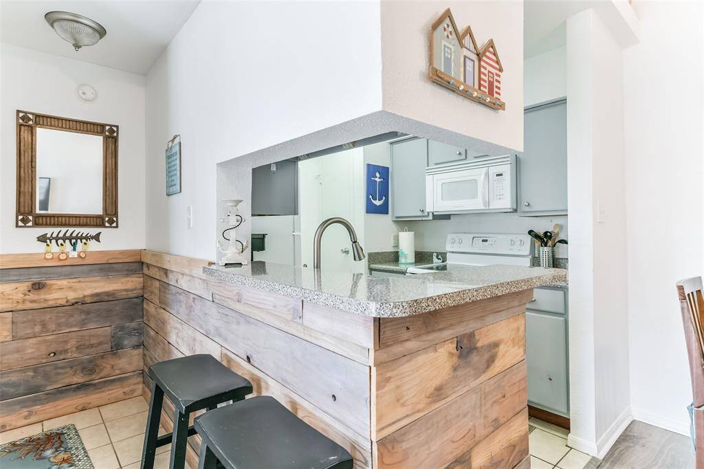 Entryway has a breakfast bar wrapped with wood paneling.