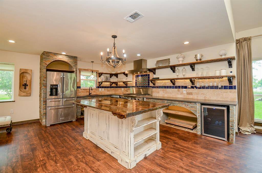 Custom kitchen with island, copper sink, wine fridge and Thermador range