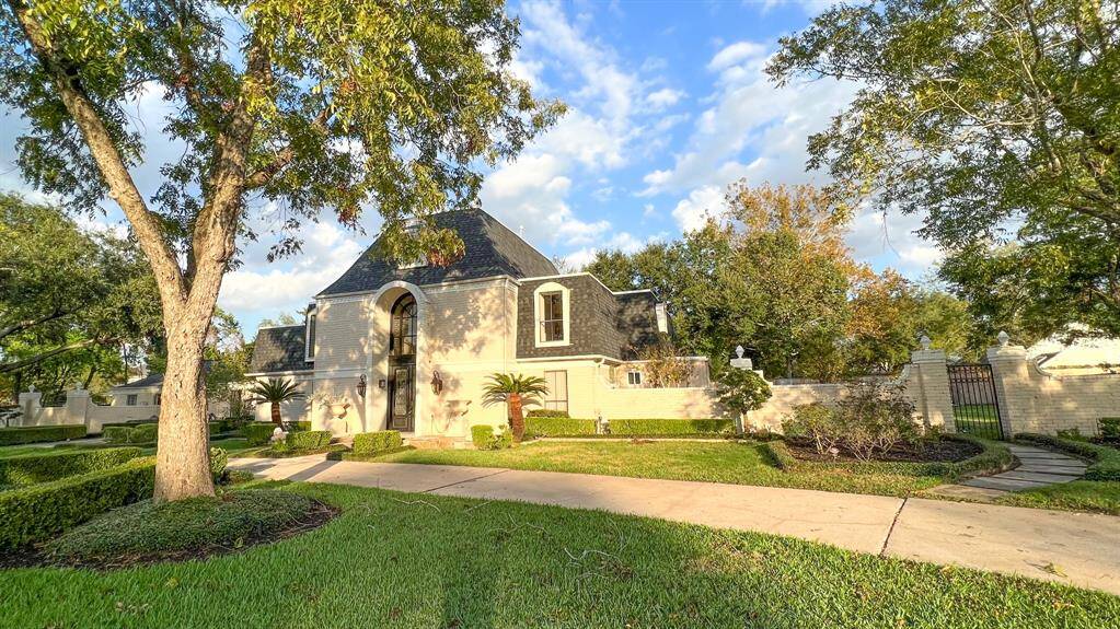 Every angle offers a fresh perspective, and walking up to the home is a true delight. The property boasts mature trees, manicured landscaping, and a stunning brick exterior. A long driveway and a t2o-car garage tucked behind the home enhance its curb appeal.