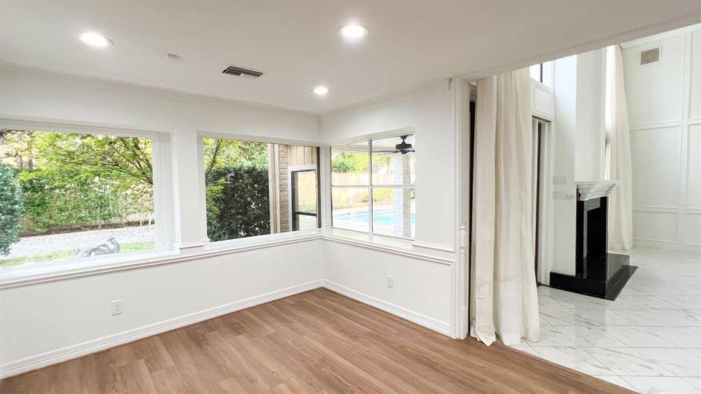 The breakfast room is quietly situated to the left of the living room and features stunning views of the backyard. Recently installed wide plank flooring flows throughout the home.